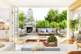 Interior of a modern home with accordion glass doors connecting a large back patio with a living room and kitchen.