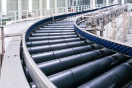 Roller conveyor system in a production line, designed for the efficient transportation of objects using cylindrical rollers.