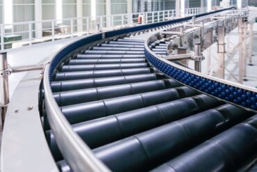 Roller conveyor system in a production line, designed for the efficient transportation of objects using cylindrical rollers.