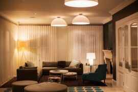 A living room that has a lot of lights on. The lights are all dimmed, making the space feel a lot more cozy.