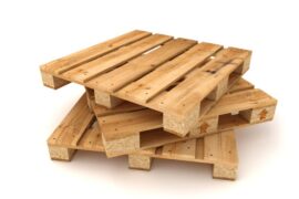 Three wooden pallets are stacked on top of each other, each slightly turned. They sit on a white background.
