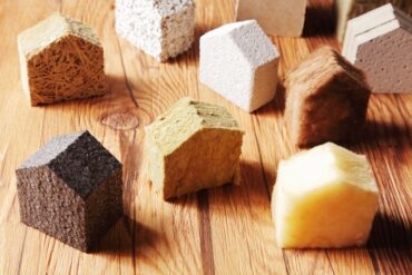 A range of different insulation types, from natural to synthetic, cut and shaped to resemble the shape of a home.