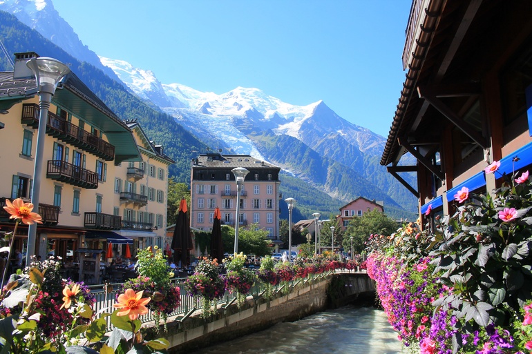 The town of Chamonix, France in the French Alps at springtime. There are snowcapped mountains in the background.