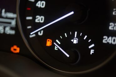 A close-up of a car's tachometer. The RPM rests at zero with the fuel needle on empty and the gas light on.