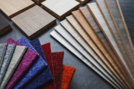 A set of wood and fabric material samples arranged on a dark surface with colorful textured swatches.