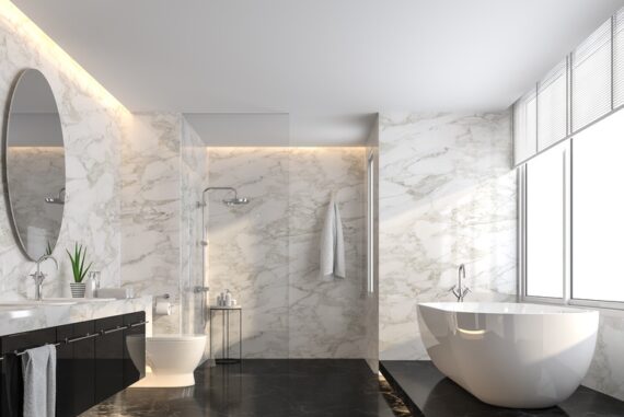 Luxury bathroom with white marble walls, black floors, a freestanding soaking tub, glass shower, and black vanity.